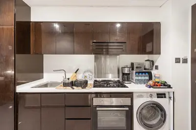 a kitchen with a sink and a stove top oven at High Floor Balcony Suite 8 mins to Burj Khalifa in Dubai