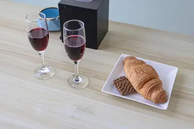 a plate of bread and two glasses of wine at High Floor Balcony Suite 8 mins to Burj Khalifa in Dubai