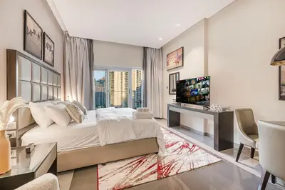 a bedroom with a large bed and a television at High Floor Balcony Suite 8 mins to Burj Khalifa in Dubai