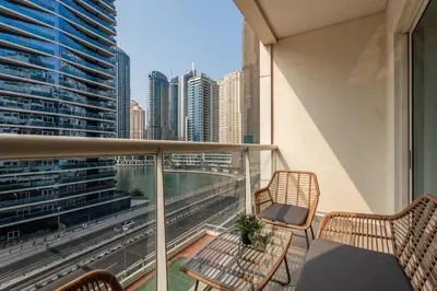a balcony with two chairs and a view of the city at Gala Guests - Marina Views Bright Balcony Collection in Dubai
