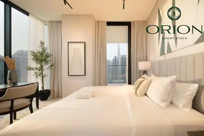a bedroom with a large white bed and a desk at Luxury 2BR with Private Jacuzzi Burj & Canal Views MINUTES FROM DUBAI MALL AND BURJ KHALIFA in Dubai