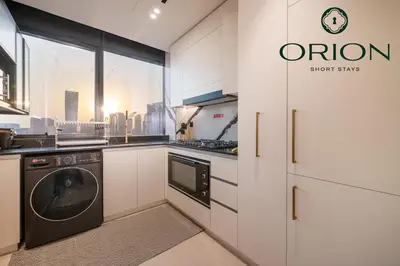 a kitchen with a washer and dryer in it at Luxury 2BR with Private Jacuzzi Burj & Canal Views MINUTES FROM DUBAI MALL AND BURJ KHALIFA in Dubai
