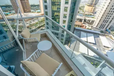 a balcony with chairs and a table and buildings at Elegant 1BR Apartment with Partial Sea View by EE holiday homes in Dubai