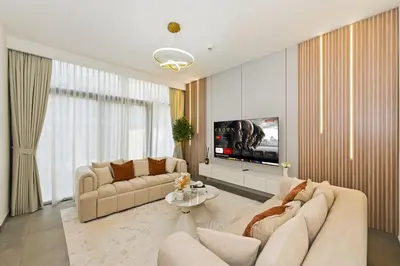 a living room with two couches and a flat screen tv at Golden Stays - Stylish 4BR Villa I Garden, Pool & Parking I Global Village in Dubai