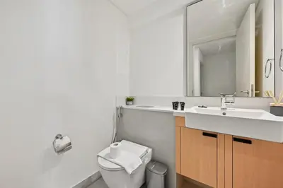 a bathroom with a sink and a toilet and a mirror at Golden Stays - Stylish 4BR Villa I Garden, Pool & Parking I Global Village in Dubai