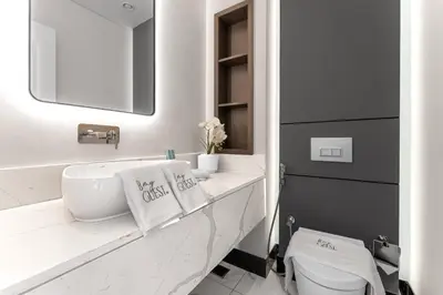 a white bathroom with a sink and a mirror at Luxury 1BR Terraces Private Jacuzzi Business Bay in Dubai