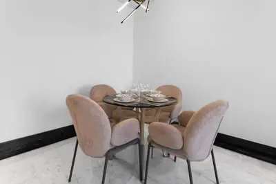 a dining room table with four chairs and a table with glasses on it at Luxury 1BR Terraces Private Jacuzzi Business Bay in Dubai