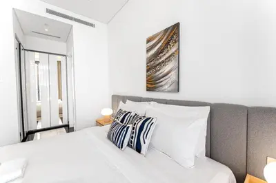 a bedroom with a white bed with two pillows at Luxury 1BR Terraces Private Jacuzzi Business Bay in Dubai