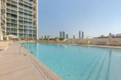 a large swimming pool in the middle of a building at Waves - Comfy and Stylish 1BR with Huge Balcony in Dubai