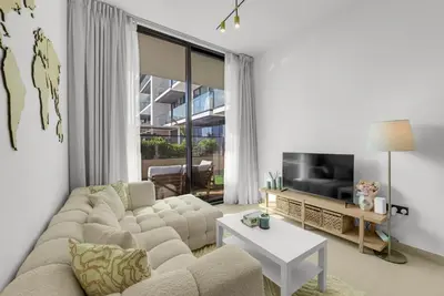 a living room with a couch and a tv at Waves - Comfy and Stylish 1BR with Huge Balcony in Dubai