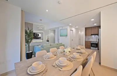 a dining room and living room with a table and chairs at Golden Stays - Chic 4BR Retreat I Luxe Touches & Serene Views in Dubai