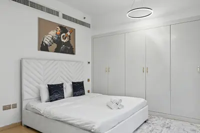 a white bedroom with a large white bed in it at Stylish 3BR JBR l Steps to Beach l Balcony l Sleeps 6 in Dubai