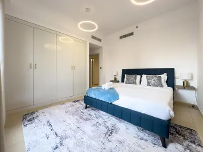 a bedroom with a large bed and white cabinets at Stylish 3BR JBR l Steps to Beach l Balcony l Sleeps 6 in Dubai
