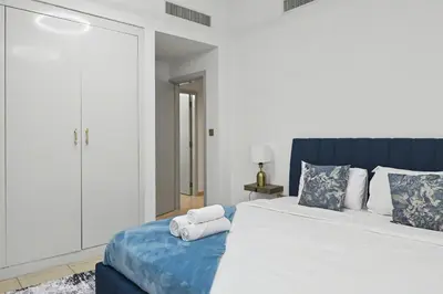 a bedroom with a bed with two towels on it at Stylish 3BR JBR l Steps to Beach l Balcony l Sleeps 6 in Dubai
