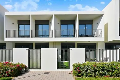 a white building with balconies and bushes at Golden Stays - Modern Luxe 4BR Oasis I Peaceful Views in Dubai