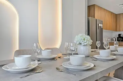 a table with plates and wine glasses on it at Golden Stays - Modern Luxe 4BR Oasis I Peaceful Views in Dubai