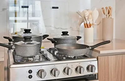 two pots and pans on a stove in a kitchen at Golden Stays - Modern Luxe 4BR Oasis I Peaceful Views in Dubai