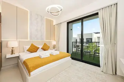 a white bedroom with a bed and a balcony at Golden Stays - Modern Luxe 4BR Oasis I Peaceful Views in Dubai