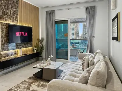 a living room with a couch and a tv at Breathtaking 2BR in Marina - Steps to Metro in Dubai