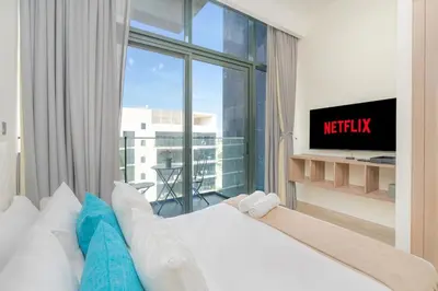 a bedroom with a bed and a large window at Chic Urban Studio l Poolside Living l Balcony in Dubai