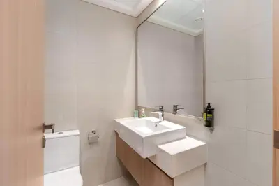 a white bathroom with a sink and a mirror at Chic Urban Studio l Poolside Living l Balcony in Dubai