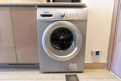 a washing machine is sitting in a room at Chic Urban Studio l Poolside Living l Balcony in Dubai