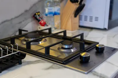 a stove top with four burners on a kitchen counter at Chic Urban Studio l Poolside Living l Balcony in Dubai