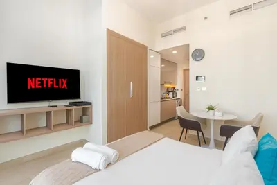 a hotel room with a bed and a tv at Chic Urban Studio l Poolside Living l Balcony in Dubai