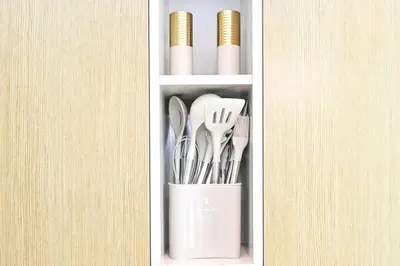 a cup filled with utensils sitting on a shelf at Golden Stays - Tranquil 4BR Villa I Pool & Coastal Charm in Dubai