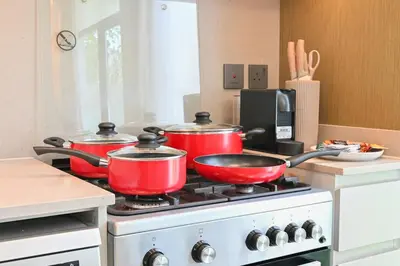 three pots and pans on a stove in a kitchen at Golden Stays - Tranquil 4BR Villa I Pool & Coastal Charm in Dubai