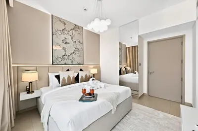 a white bedroom with a large bed with a tray on it at Golden Stays - Tranquil 4BR Villa I Pool & Coastal Charm in Dubai