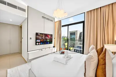 a bedroom with a white bed and a large window at Golden Stays - Tranquil 4BR Villa I Pool & Coastal Charm in Dubai
