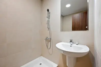 a white bathroom with a sink and a shower at Golden Stays - Palm Views I Luxe 4BR Getaway I Tranquil Charm in Dubai
