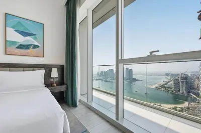 a bedroom with a bed and a large window at Golden Stays - Palm Views I Luxe 4BR Getaway I Tranquil Charm in Dubai