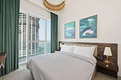 a bedroom with a bed and a large window at Golden Stays - Palm Views I Luxe 4BR Getaway I Tranquil Charm in Dubai