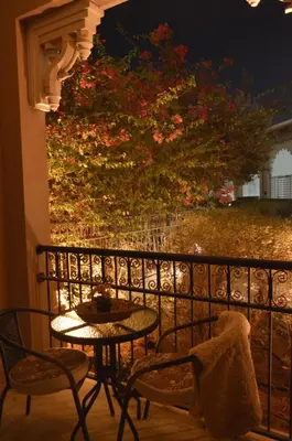 a table and chairs on a balcony with a tree at Ramadan Staycay King suite sunset stay sauna beachfront tennis pool and 24h security in Dubai