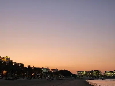 a view of a beach at sunset with buildings at Ramadan Staycay King suite sunset stay sauna beachfront tennis pool and 24h security in Dubai