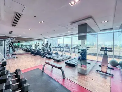 a gym with treadmills and ellipticals in a building at GuestReady - Studio l Close to Metro Station in Dubai