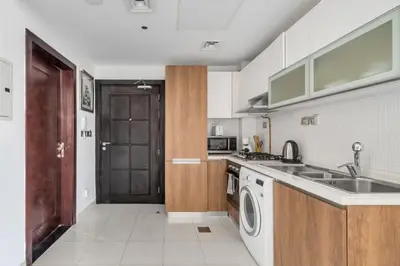 a kitchen with a sink and a washing machine at GuestReady - Studio l Close to Metro Station in Dubai