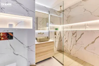 a bathroom with marble walls and a glass shower at bnbmehomes - Murjan 5 in Dubai