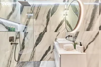 a bathroom with a shower and a sink and a mirror at bnbmehomes - Murjan 5 in Dubai