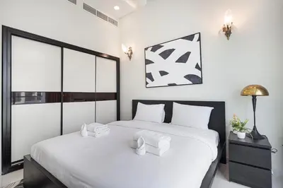 a bedroom with a large bed with white sheets at Modern 4Bedroom Villa in Al Furjan in Dubai