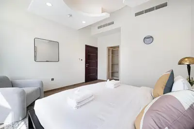 a white bedroom with a bed and a couch at Modern 4Bedroom Villa in Al Furjan in Dubai
