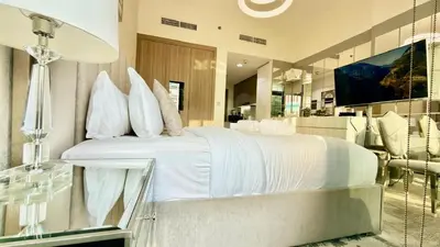 a bedroom with a white bed and a mirror at Luxury Stay in Meydan - 10min to Downtown in Dubai