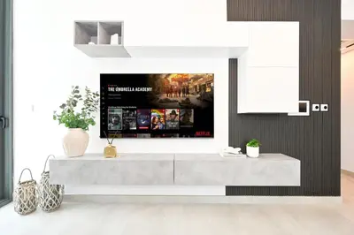 a living room with a tv on a wall at Golden Stays - Luxe 1BR Retreat I Cinema Access & Elegant Stay in Dubai