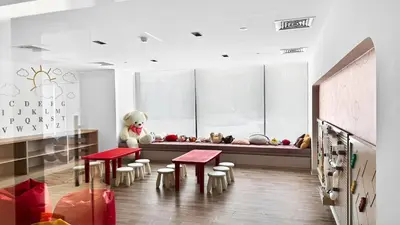 a room with two tables and a bench with stuffed animals at Golden Stays - Luxe 1BR Retreat I Cinema Access & Elegant Stay in Dubai