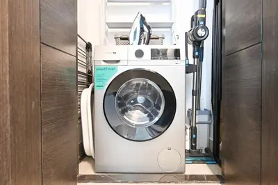 a washer and dryer in a room at Golden Stays - Luxe 1BR Retreat I Cinema Access & Elegant Stay in Dubai