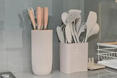 two white containers with utensils on a counter at Golden Stays - Luxury 1BR Apartment I Cinema Access I Pool & Gym in Dubai