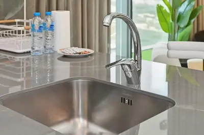 a stainless steel kitchen sink in a kitchen at Golden Stays - Luxury 1BR Apartment I Cinema Access I Pool & Gym in Dubai