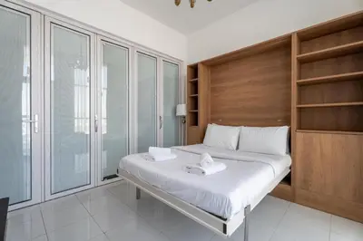 a bedroom with a bed with white sheets and wooden walls at GuestReady - 1BR l Close to Metro Station in Dubai